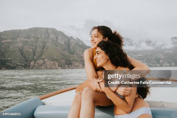 two woman embrace during a romantic boat ride - speaking engagement stock pictures, royalty-free photos & images