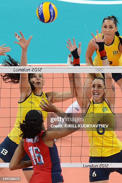 Foluke Akinradewo plays as Brazil's Sheilla Castro and Thaisa Menezes attempt to block during the women's preliminary pool B volleyball match between...
