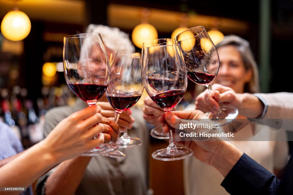 Glückliche Gruppe von Menschen, die bei einer Weinprobe anstoßen