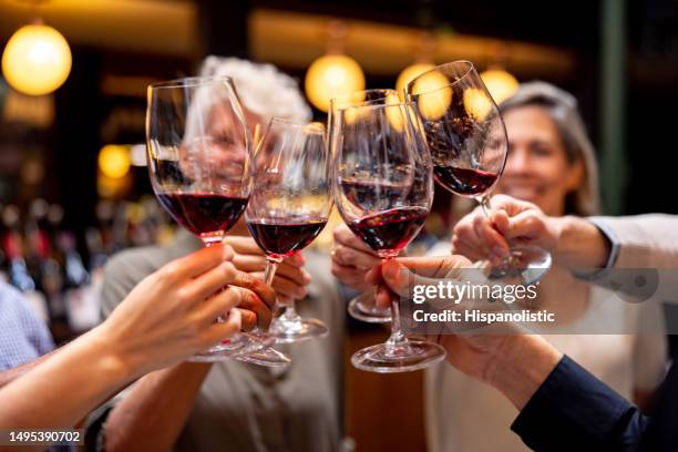 glückliche gruppe von menschen, die bei einer weinprobe anstoßen - wine tasting stock-fotos und bilder