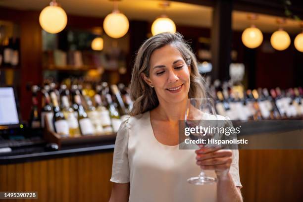 happy woman holding a glass of wine at a wine tasting - sommelier stockfoto's en -beelden