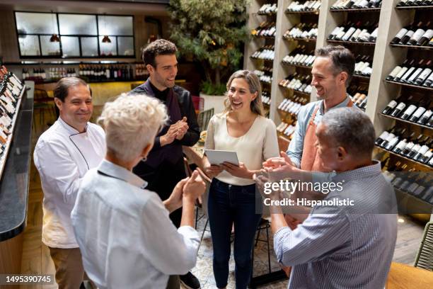 business owner having a pep talk with her team at a restaurant - team talk stockfoto's en -beelden