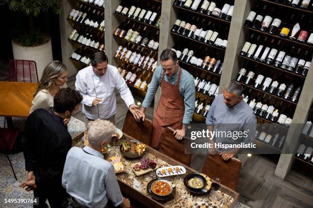 chef che presenta un nuovo menu al suo team in un ristorante - degustazione di vino foto e immagini stock