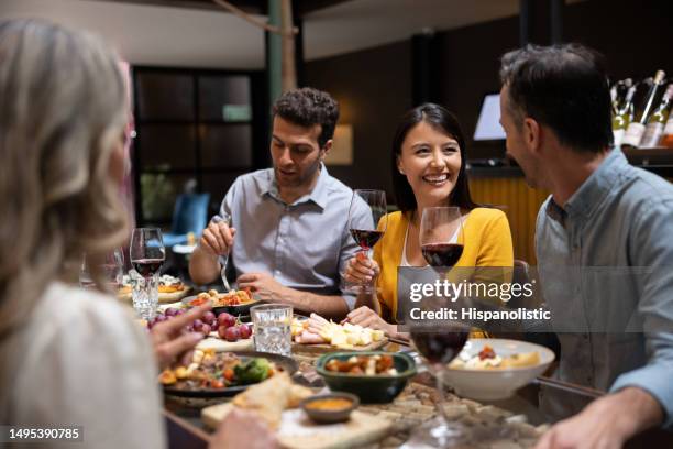 happy woman having dinner with a group of friends - winebar stock pictures, royalty-free photos & images