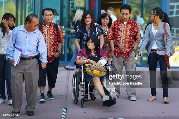 Rita Paulina who was wounded during the shooting at the screening of The Dark Knight Rises leaves in a wheelchair with her family from the Arapahoe...