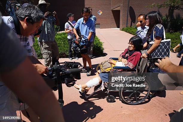 Rita Paulina who was wounded during the shooting at the screening of The Dark Knight Rises leaves in a wheelchair with her family from the Arapahoe...