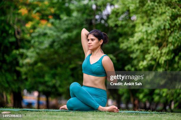 young yogi attractive woman in cow face pose or gomukhasana - yoga instructor stock pictures, royalty-free photos & images