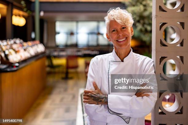happy chef working at a restaurant and smiling - old woman tattoos stock pictures, royalty-free photos & images