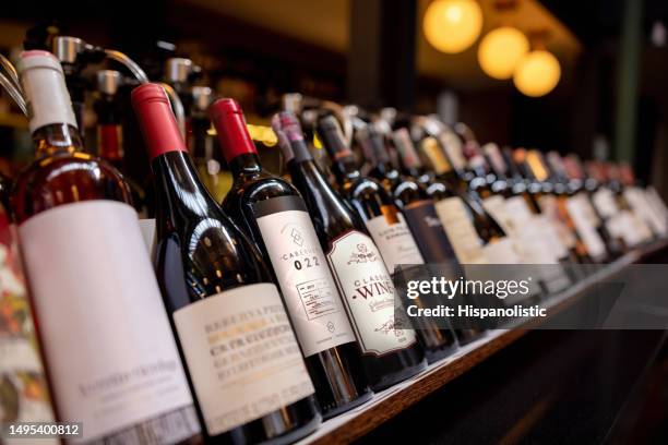 close-up on bottles of wine displayed at a winery - wine cellar stock pictures, royalty-free photos & images