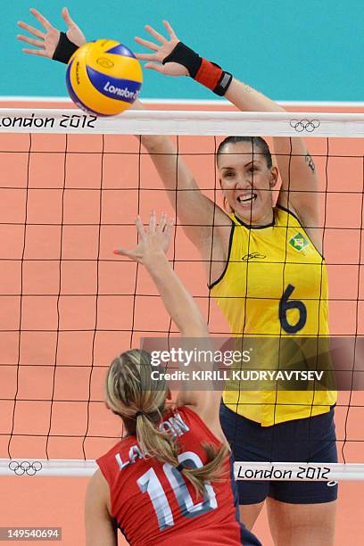 Player Jordan Larson spikes the ball as Brazil's Thaisa Menezes attempts to block during the women's preliminary pool B volleyball match between the...