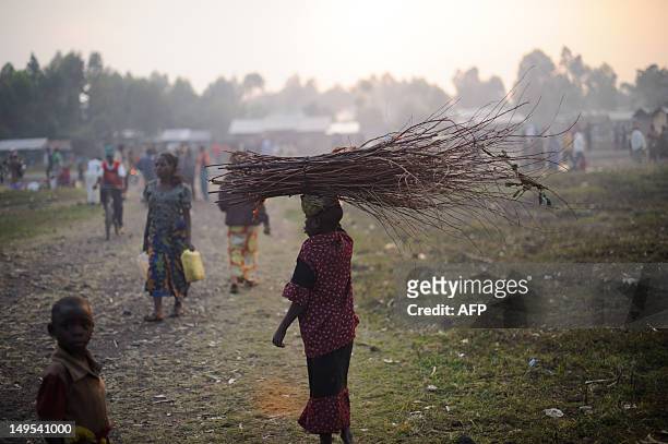 Displaced Congolese girl carries firewood in a camp in the village of Kanyarucinya in the village of Kanyarucinya in Kibati district on the outskirts...