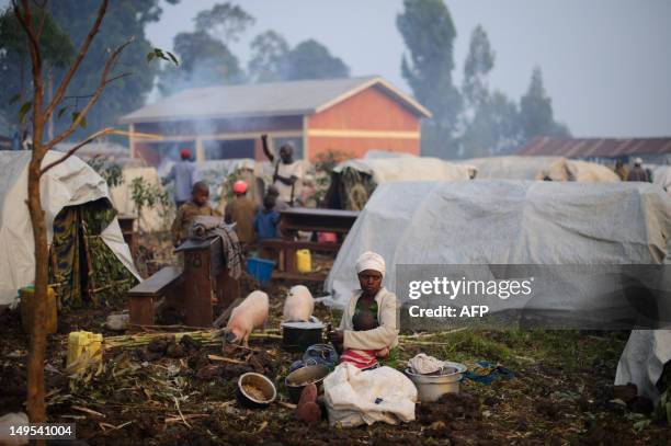 Displaced Congolese lady sits with her child sit beside their makeshift tent in a camp set-up in the village of Kanyarucinya in Kibati district on...