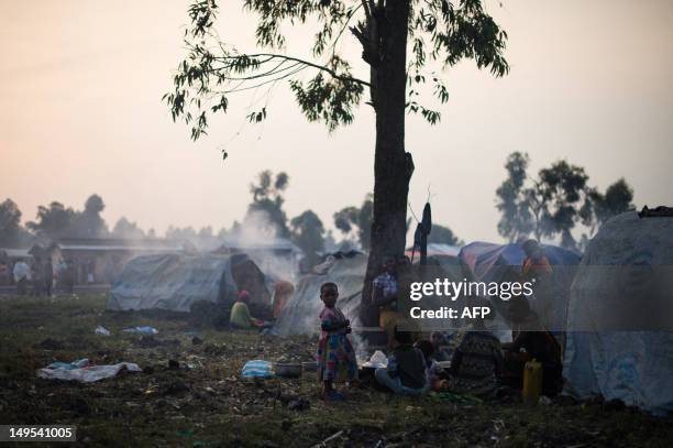 Displaced Congolese family sit beside their makeshift tent in a camp set-up in the village of Kanyarucinya in Kibati district on the outskirts of...