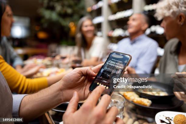 customer at a restaurant rating his experience on a mobile app - feedback stockfoto's en -beelden