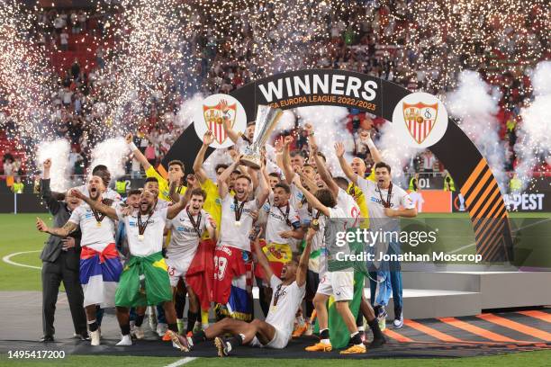 Ivan Rakitic and Jesus Navas of Sevilla lift the trophy as they celebrates with team mates following the penalty shoot out victory in the UEFA Europa...