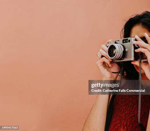 a woman takes a photo using a digital camera. space for copy. - digitalkamera stock-fotos und bilder