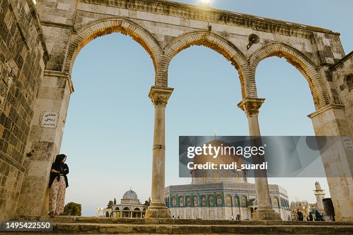 Asian muslim woman leaning at the wall with dome of rock at the background Asian muslim woman leaning at the wall with dome of rock at the background
