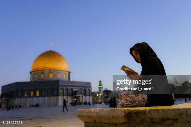 asian muslim woman  reading al qur'an  with dome of rock at the background - jerusalem sunrise stock pictures, royalty-free photos & images