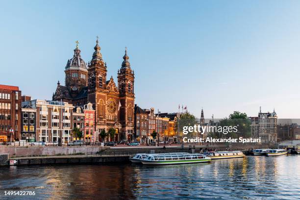 basilica of saint nicholas and amsterdam skyline at dusk, netherlands - amstel stockfoto's en -beelden