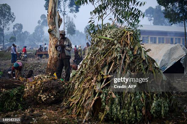 Displaced Congolese man stands next to his temporary shelter made of sticks and leaves at a camp set-up in the village of Kanyarucinya in Kibati...