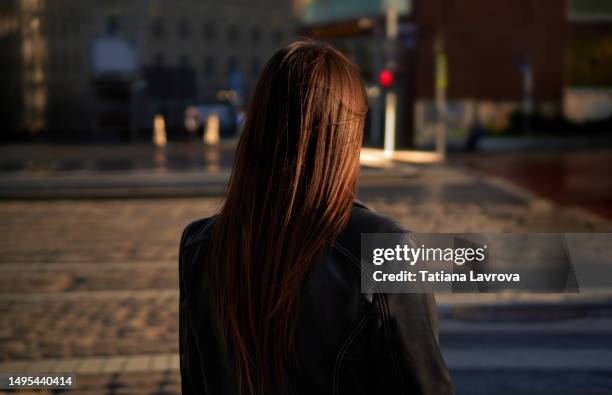 lonely woman standing on the street with her back to the camera. depression, mental health, stress, illness, sadness, emotional abuse concept - harassment work stock pictures, royalty-free photos & images