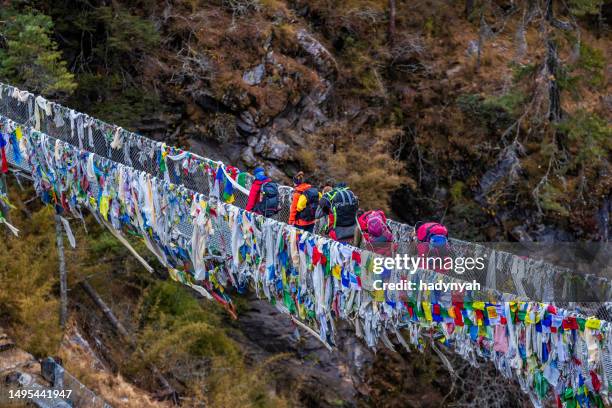 group of trekkers crossing suspension bridge near namche bazaar, mount everest national park - solu khumbu stock pictures, royalty-free photos & images