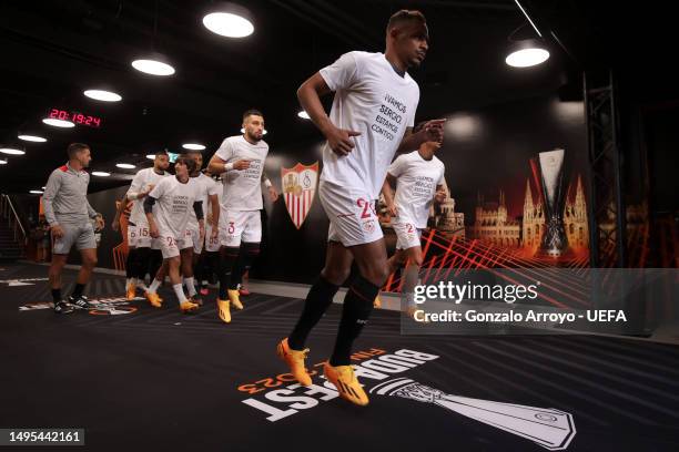 Fernando of Sevilla FC walks out of the tunnel with teammates before warming up wearing a t-shirt in support of Sergio Rico of Paris Saint-Germain,...