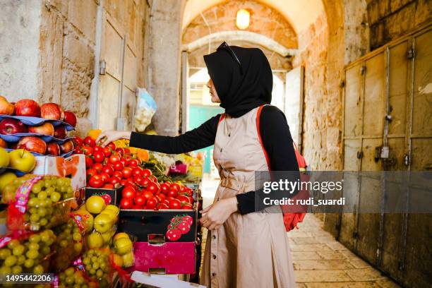 mujer musulmana asiática comprando fruta en el mercado callejero en la ciudad vieja de jerusalén - ciudad vieja jerusalén fotografías e imágenes de stock