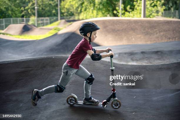 boy riding push scooter at the outdoors pumptrack - swoosh stock pictures, royalty-free photos & images