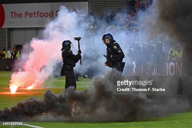 Riot police stand in front the away sector of Bielefeld supporters1 during the Second Bundesliga playoffs first leg match between SV Wehen Wiesbaden...