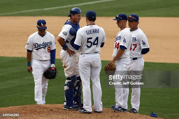 Catcher A.J. Ellis of the Los Angeles Dodgers talks with relief pitcher Javy Guerra about how to pitch to Hunter Pence of the Philadelphia Phillies...