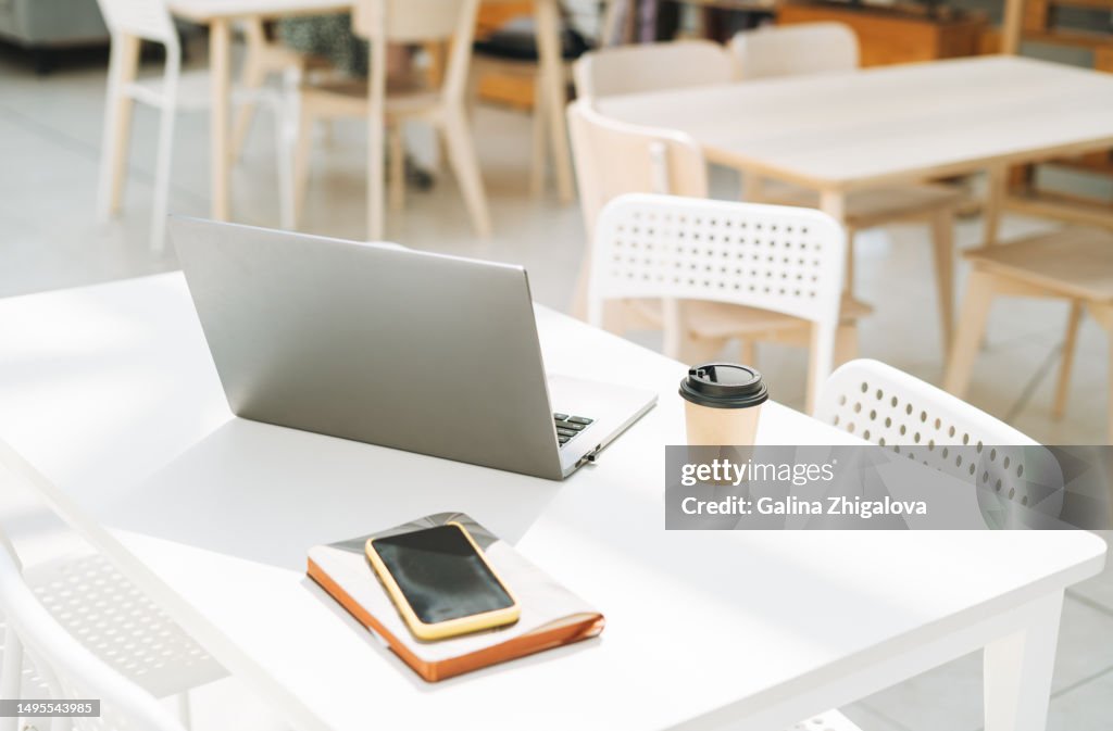 Lifestyle business still life with open laptop and cup of coffee on desk in office