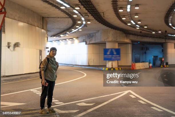 a female tourist is waiting for a taxi at an underground station in the city - air taxi stock pictures, royalty-free photos & images