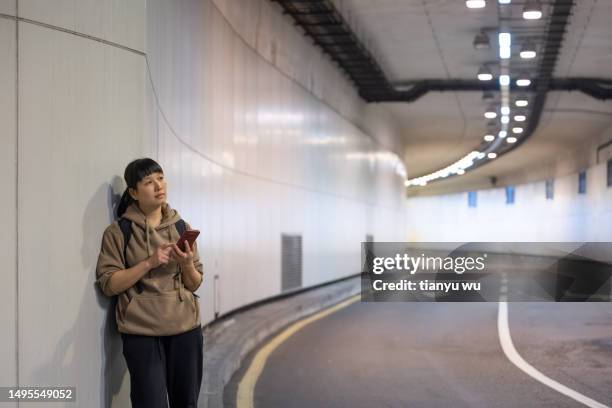 a female tourist is waiting for a bus at an underground bus stop in the city - air taxi stock pictures, royalty-free photos & images