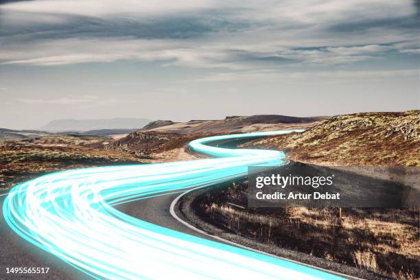 electric blue light trails flowing in a winding road connecting globally remote locations. - climate finance stock pictures, royalty-free photos & images