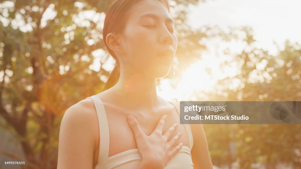 Young Asian women healthy lifestyle practice yoga outdoors standing in city park. Healthy lifestyle and exercises.