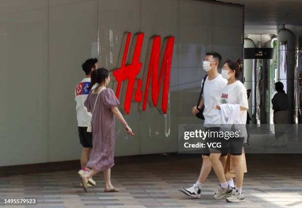 People walk past an H&M clothing store at Sanlitun on June 3, 2023 in Beijing, China. H&M will close its flagship store in Beijing's Sanlitun on June...