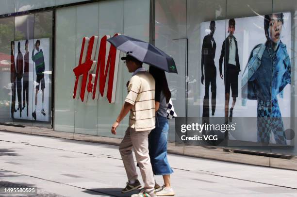 People walk past an H&M clothing store at Sanlitun on June 3, 2023 in Beijing, China. H&M will close its flagship store in Beijing's Sanlitun on June...