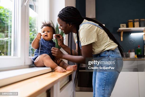 mom wiping her baby boy's face with wet wipes - baby wipes stock pictures, royalty-free photos & images