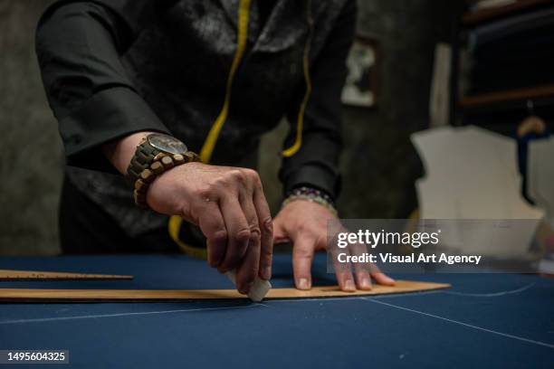 men fashion designer is drawing cloth fabric with soap and miter focus on foreground close up horizontal fashion still - tailor stock pictures, royalty-free photos & images