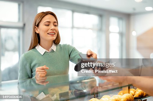 Woman Paying at a Bakery Shop With Smartphone Woman Paying at a Bakery Shop With Smartphone