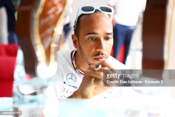 Lewis Hamilton of Great Britain and Mercedes signs an autograph on a trophy from the cancelled F1 Grand Prix of Emilia Romagna which will be...