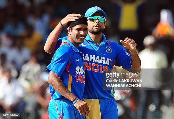 Indian cricketer Ashok Dinda celebrates with teammate Virat Kohli the dismissal of Sri Lankan batsman Tillakaratne Dilshan during the fourth one day...
