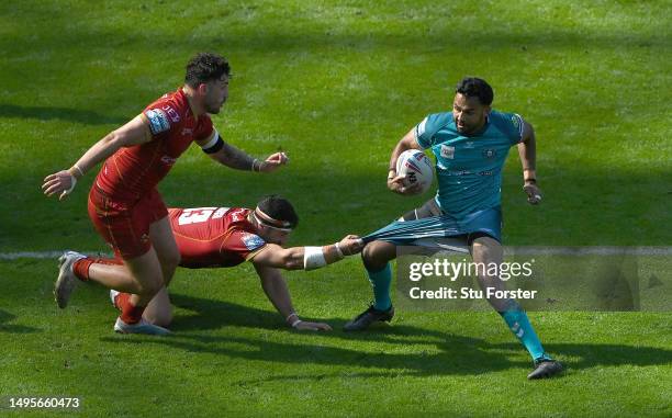 Wigan player Bevan French has his shorts pulled in the tackle by Catalan player Ben Garcia during the Betfred Super League Magic Weekend match...