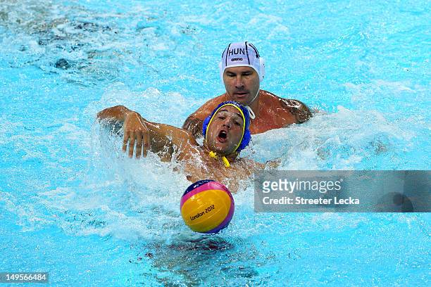 Mladan Janovic of Montenegro battles for the ball with Peter Biros of Hungary during their Men's Water Polo preliminary round Group B match on Day 4...