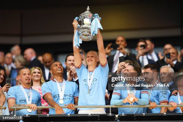 Erling Haaland of Manchester City lifts the FA Cup Trophy after the team's victory in the Emirates FA Cup Final between Manchester City and...