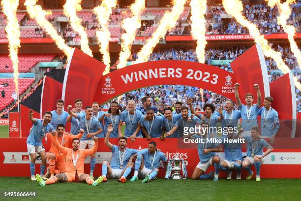 Players of Manchester City pose for a team photograph with the FA Cup Trophy after defeating Manchester United during the Emirates FA Cup Final...