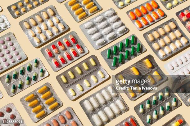 blisters with colorful pills and capsules on beige background. minimal medical, health care, pharmacology concept. - blister stockfoto's en -beelden