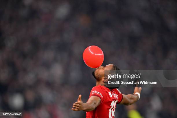 Christopher Nkunku of RB Leipzig celebrates by blowing up a balloon after scoring the team's first goal during the DFB Cup final match between RB...