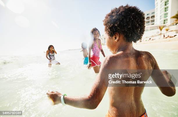 medium shot family playing in ocean during vacation at tropical resort - mexico stock pictures, royalty-free photos & images
